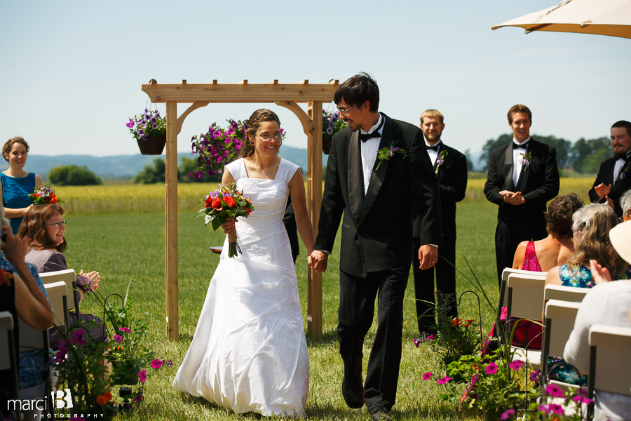 Corvallis wedding photography - bride and groom walking down aisle - grass field wedding