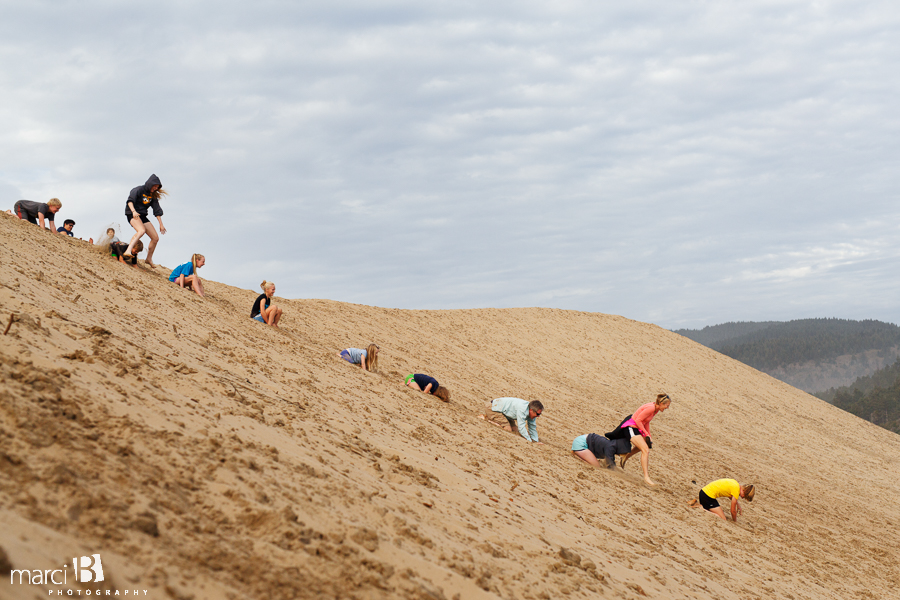 Playing on the dunes - Family photographer - Oregon Coast - leapfrog down a sand dune