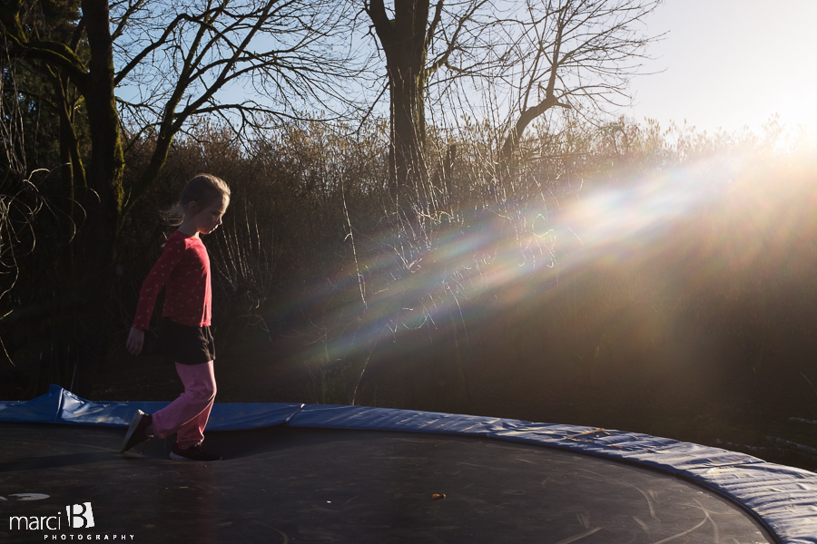 winter on the trampoline - sun in the PNW winter - girl on trampoline