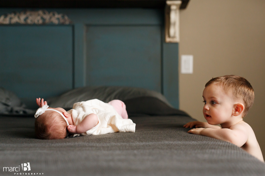 big brother looks at little sister - baby photographer