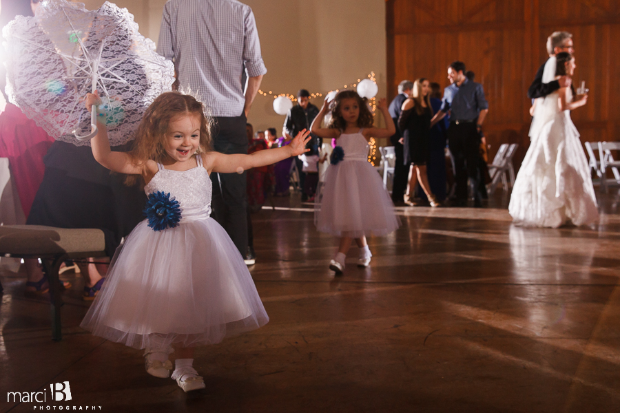 little girl dancing at reception with parasol
