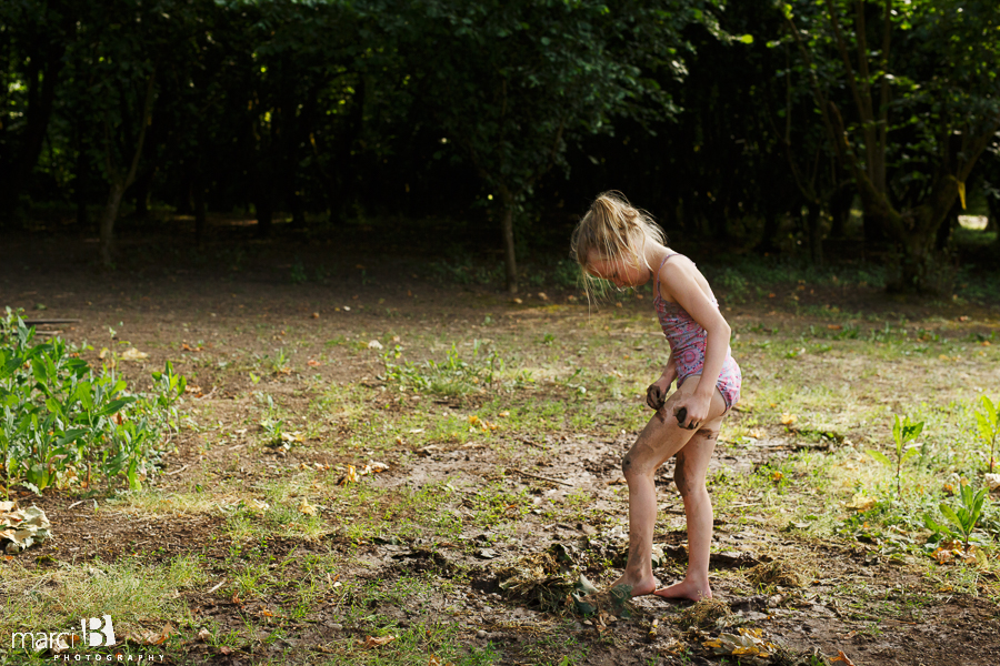summer photo of girl playing in mud