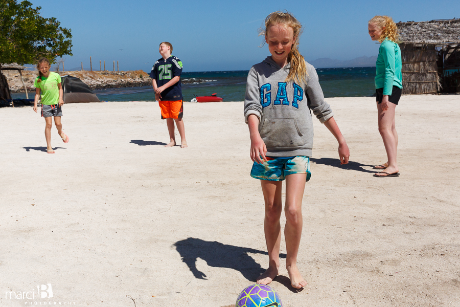 camping - kids playing soccer by beach - Baja family road trip