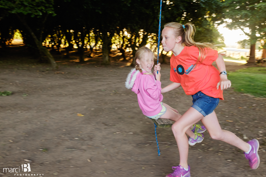 kids on swing - girl swinging - hazelnut orchard in background