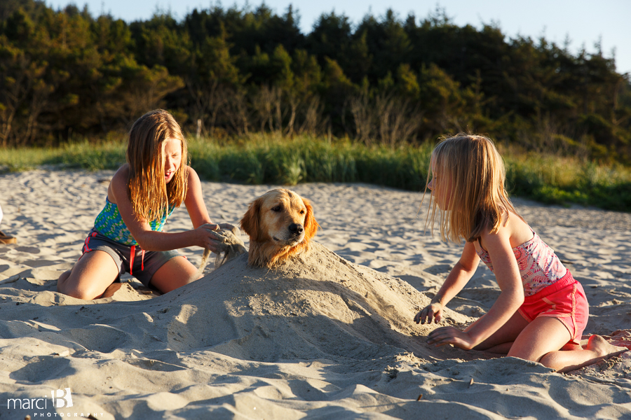 Ona Beach - burying a dog in sand - kids playing with dog on beach