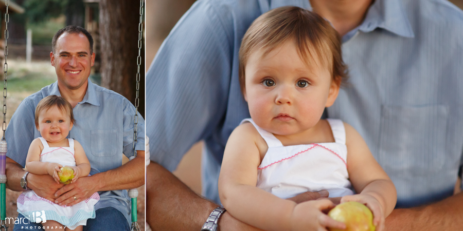 little girl in dad's lap - swinging