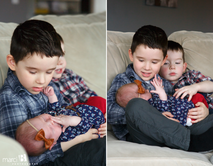 brothers hold newborn sister - newborn photography - siblings - big brothers