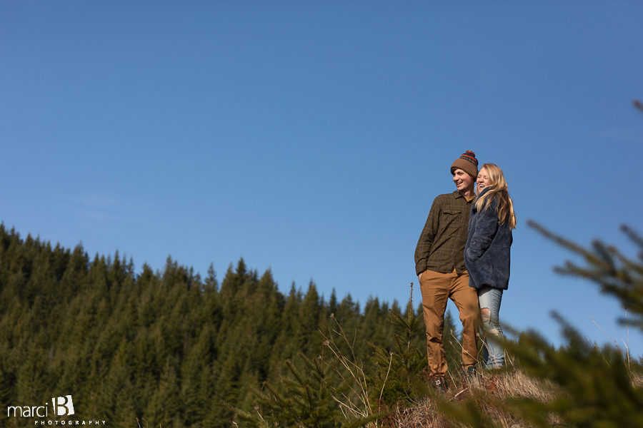 oregon engaged couple standing in the pacific northwest  overlooking green forest