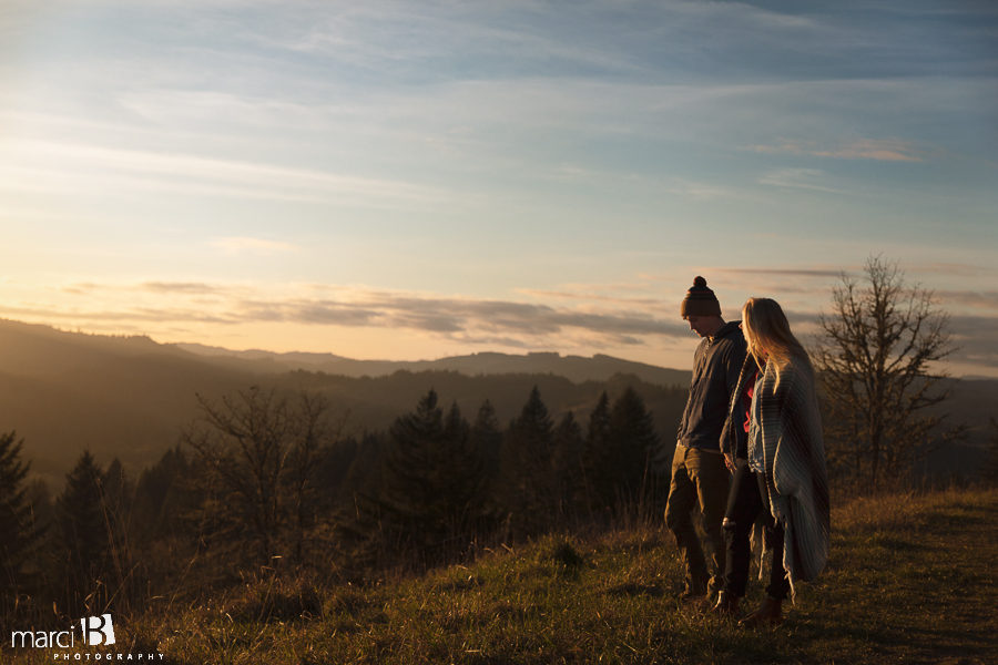 engaged couple atop coast range overlooking sunset