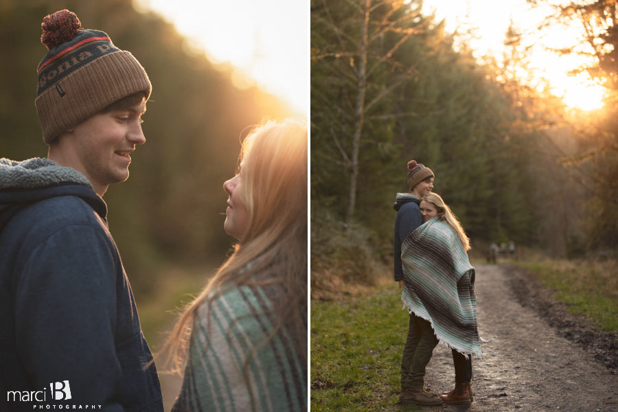 engaged couple with golden sun in background and colorful blanket