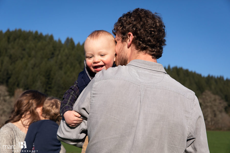 family photographer takes pictures of family with two young boys in Oregon Coast Range - family photos on the farm