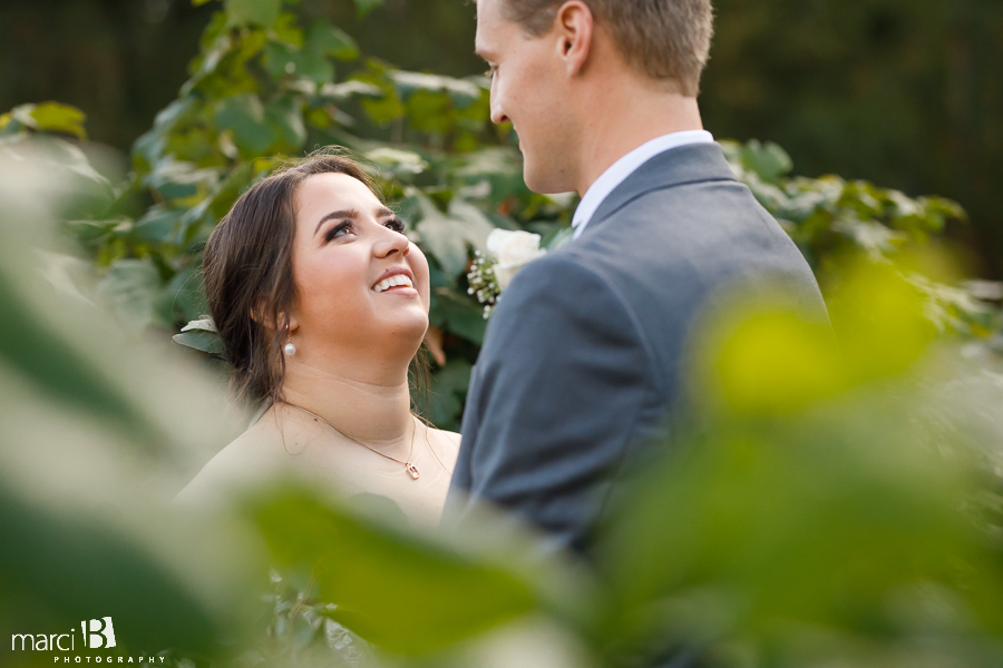 bride looking up at groom in vineyard