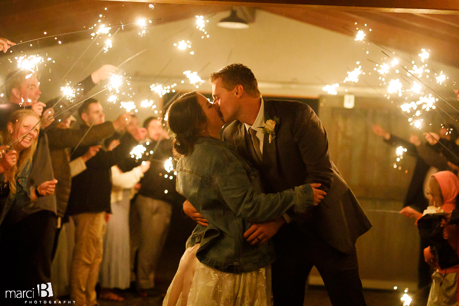 groom kisses bride with sparklers