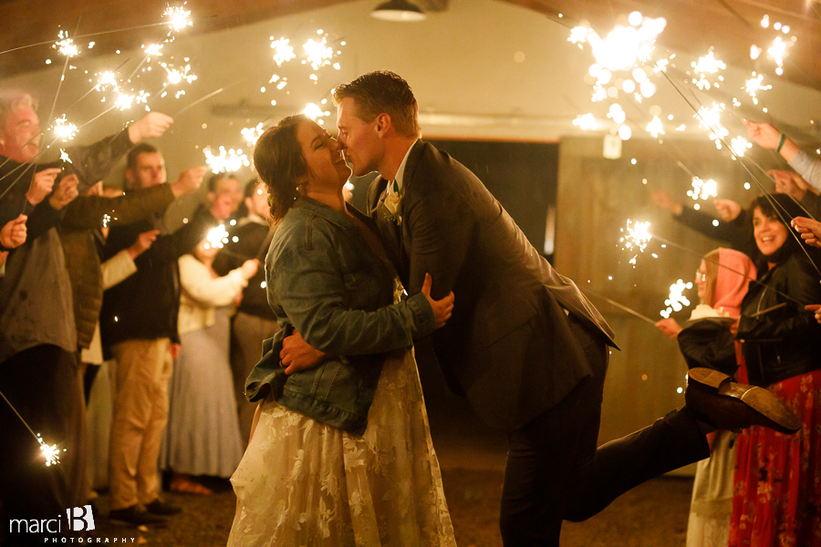 groom kisses bride with sparklers