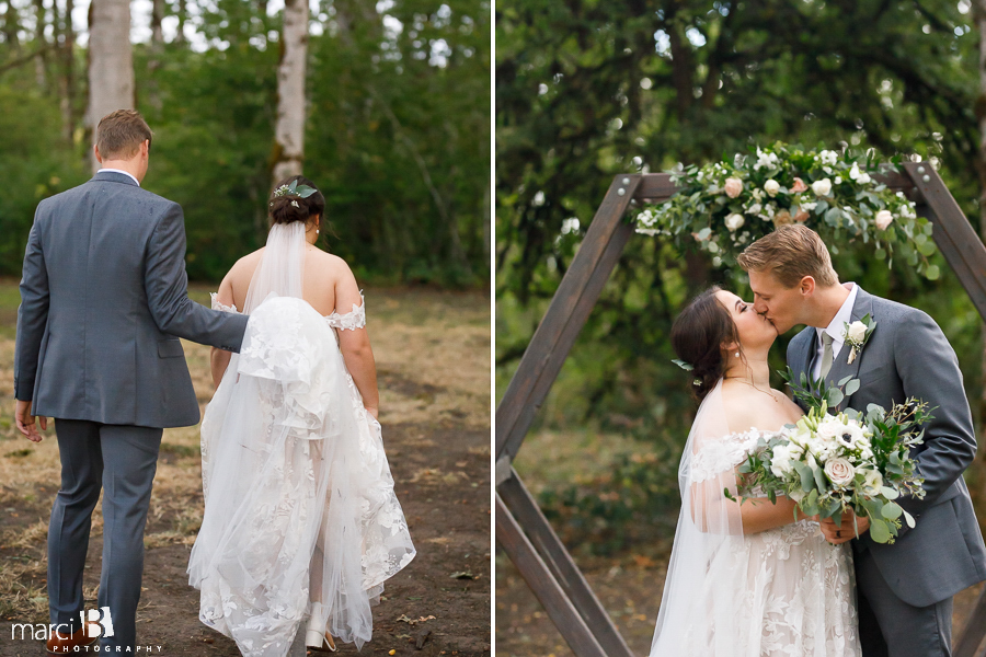 bride and groom in front of wedding arch