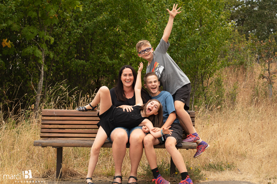 professional photographer takes picture of family on bench